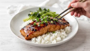 Lachs Teriyaki mit Reis: glasiertes Lachsfilet in Teriyaki-Sauce mit Sesam und Frühlingszwiebeln auf Reis